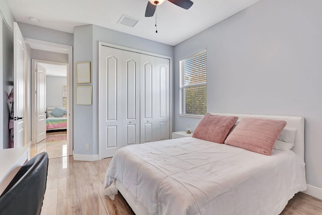 bedroom with light wood-type flooring, a closet, and ceiling fan