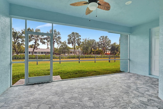 unfurnished sunroom featuring ceiling fan