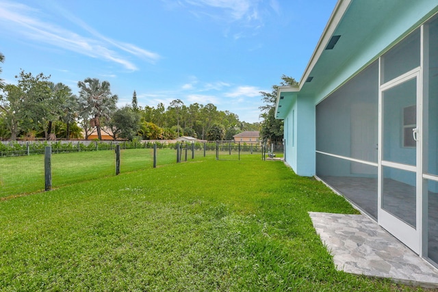 view of yard with fence and a sunroom