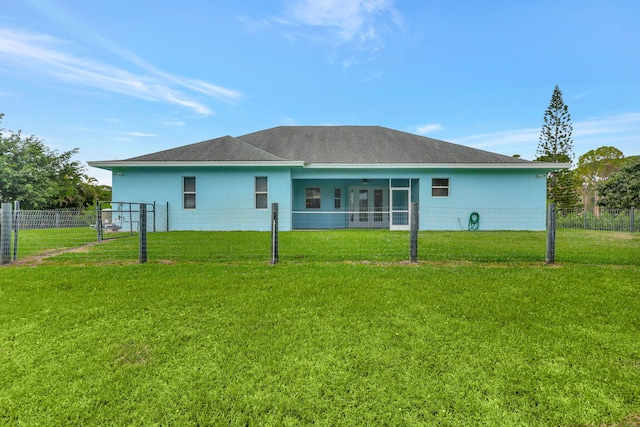 rear view of property with a sunroom, a yard, fence, and stucco siding