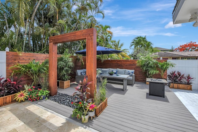 wooden deck with an outdoor living space with a fire pit