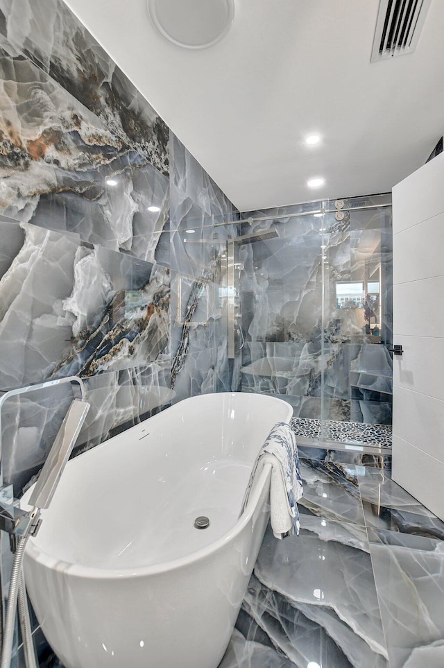 bathroom featuring separate shower and tub and tile walls