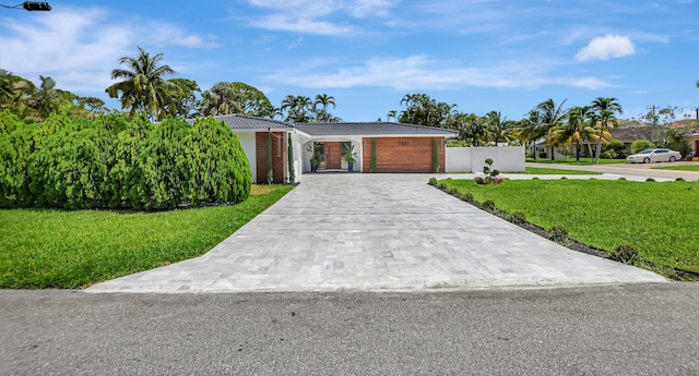 ranch-style house featuring a front yard and a garage