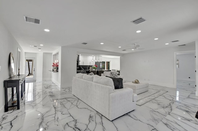 living room featuring ceiling fan with notable chandelier and a healthy amount of sunlight