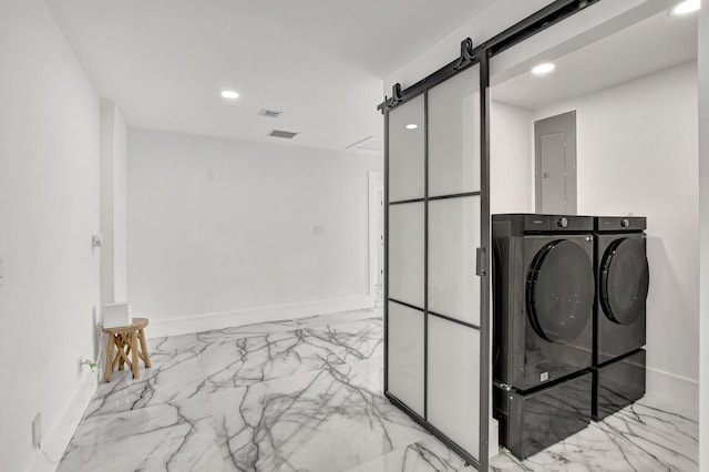 washroom featuring a barn door, electric panel, and washing machine and dryer