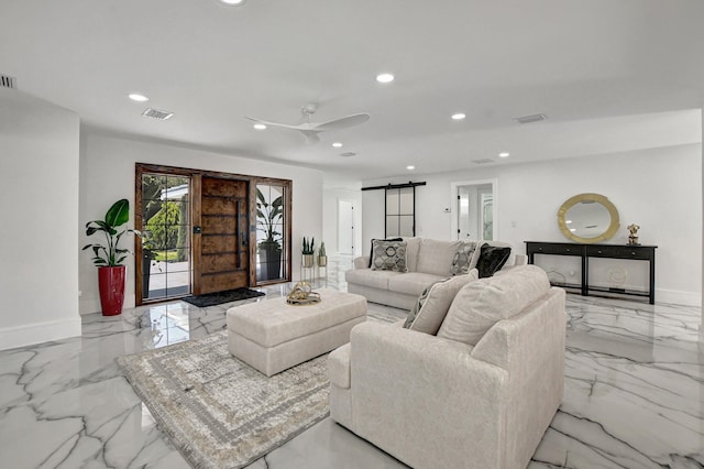 living room with ceiling fan and a barn door