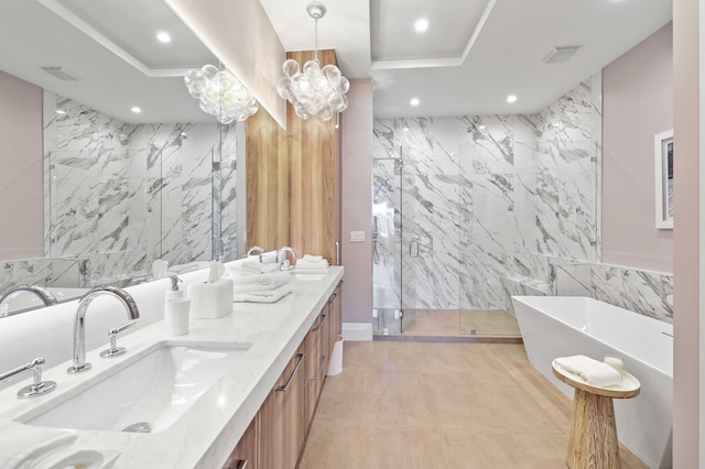 bathroom with double sink vanity, a notable chandelier, tile walls, tile patterned floors, and separate shower and tub