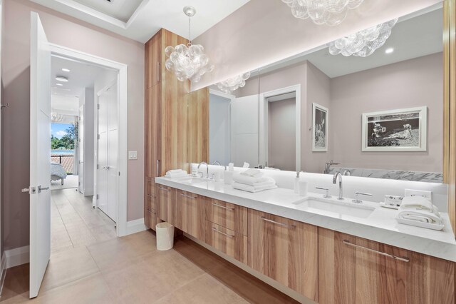 bathroom with a notable chandelier, tile patterned flooring, and dual bowl vanity