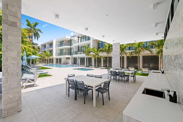 view of patio featuring a balcony and a community pool