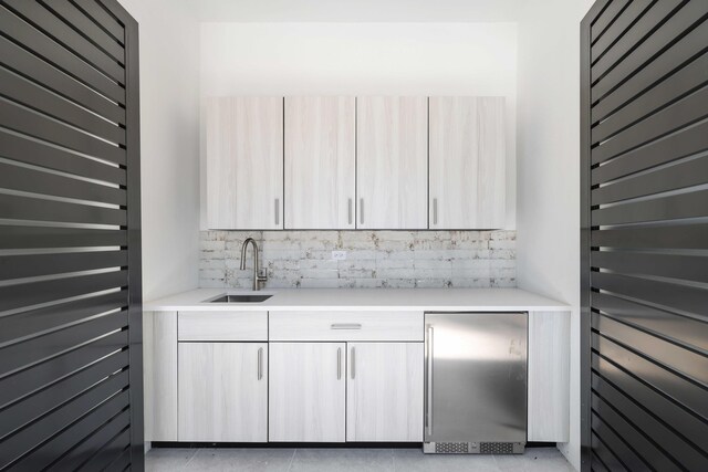 interior space featuring light brown cabinetry, tasteful backsplash, light tile patterned floors, and tile walls