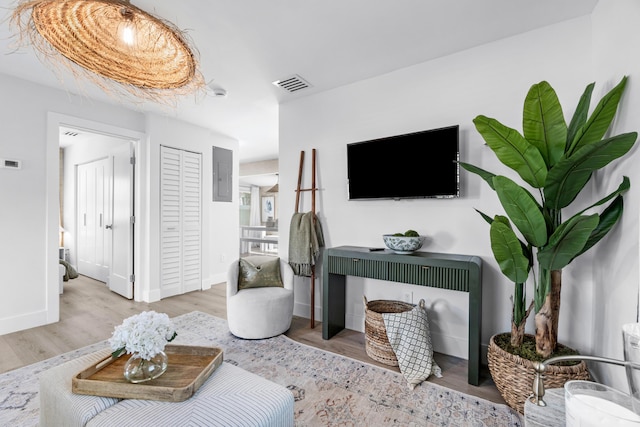 living room with electric panel and light wood-type flooring