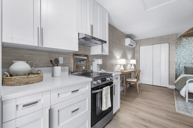 kitchen featuring white cabinetry, electric range, a wall mounted air conditioner, backsplash, and light hardwood / wood-style floors