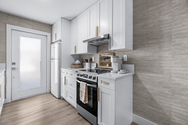 kitchen featuring stainless steel electric range, white fridge, decorative backsplash, and white cabinetry