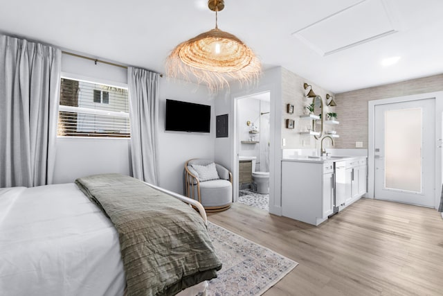 bedroom featuring sink, connected bathroom, and light hardwood / wood-style flooring