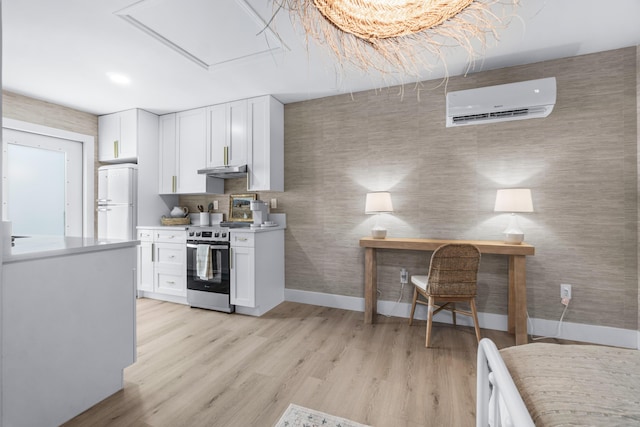 kitchen featuring a wall mounted AC, stainless steel electric range oven, white cabinets, and white refrigerator