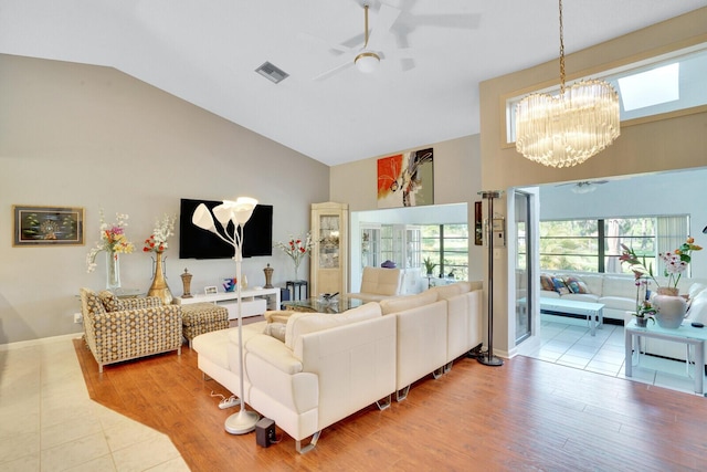 living room featuring wood-type flooring, ceiling fan with notable chandelier, and lofted ceiling