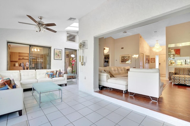 tiled living room featuring ceiling fan and vaulted ceiling