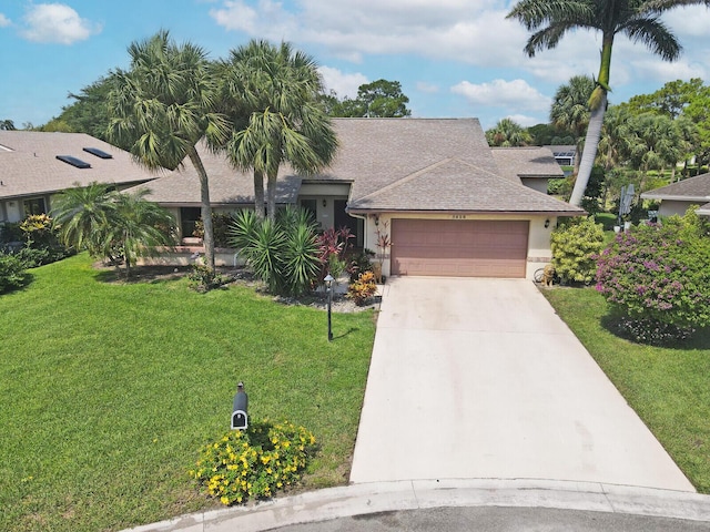 view of front of property with a front yard and a garage