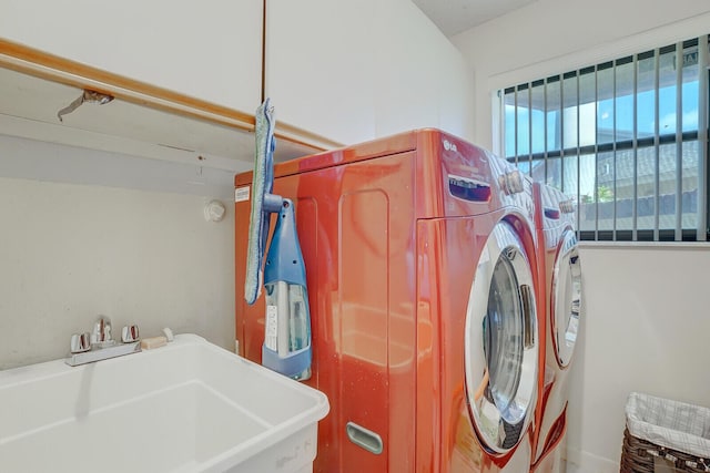 washroom with laundry area, separate washer and dryer, and a sink