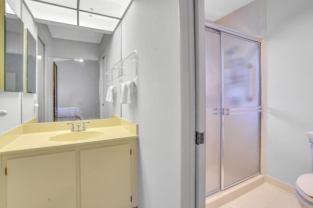 bathroom with tile patterned flooring, vanity, toilet, and walk in shower