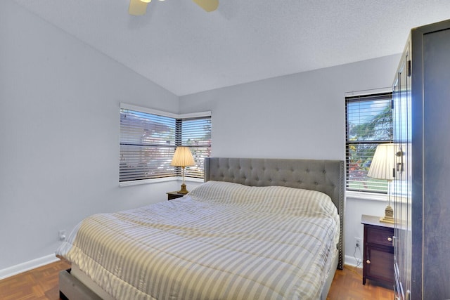 bedroom with ceiling fan, lofted ceiling, and parquet flooring