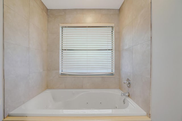 bathroom featuring tiled tub and plenty of natural light