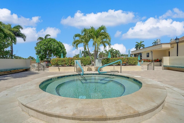 view of swimming pool featuring a hot tub and a patio