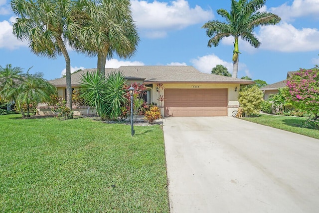 view of front of property with a garage, driveway, a front yard, and stucco siding