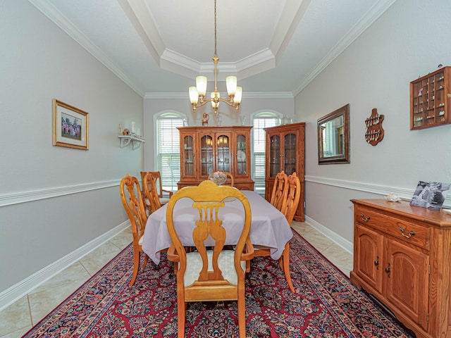 tiled dining space featuring a tray ceiling, crown molding, and an inviting chandelier