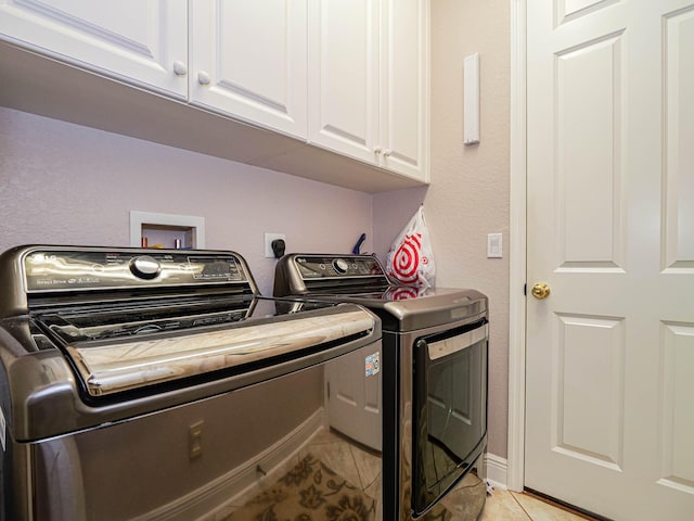 washroom featuring independent washer and dryer, washer hookup, hookup for an electric dryer, light tile floors, and cabinets