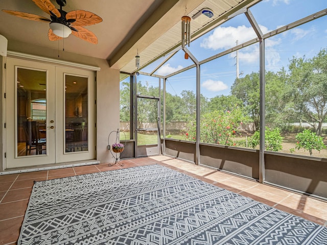 unfurnished sunroom with beamed ceiling, ceiling fan, and french doors