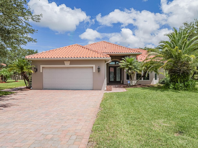 mediterranean / spanish-style home with a garage and a front yard