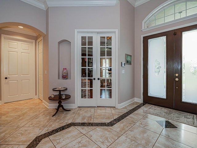 foyer with french doors, crown molding, and light tile floors