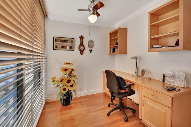 office space with built in desk, ceiling fan, crown molding, and light hardwood / wood-style flooring