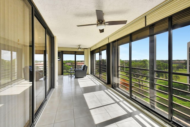 unfurnished sunroom with ceiling fan