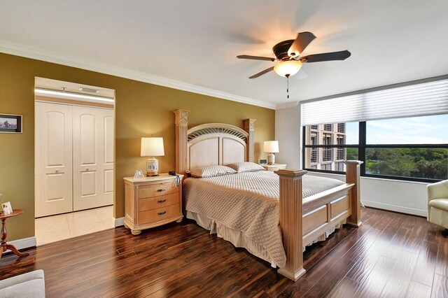 bedroom with a closet, ceiling fan, crown molding, and dark hardwood / wood-style floors