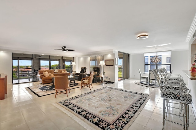 living room with ceiling fan with notable chandelier, ornamental molding, and light tile patterned floors