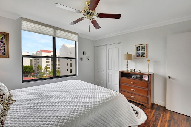 bedroom featuring a closet, ceiling fan, ornamental molding, and dark wood-type flooring