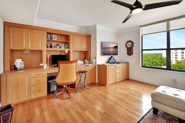 home office featuring built in desk, ornamental molding, ceiling fan, and light hardwood / wood-style flooring