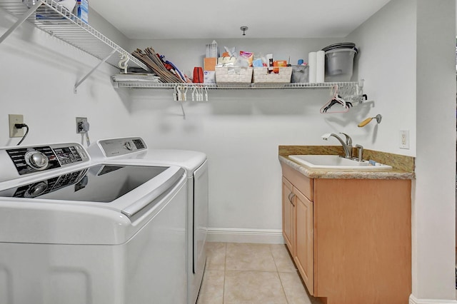 laundry room featuring independent washer and dryer, cabinets, light tile patterned floors, and sink