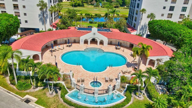 view of swimming pool featuring a hot tub and a water view