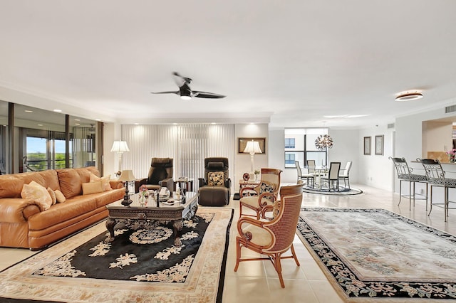 living room with ceiling fan with notable chandelier, a healthy amount of sunlight, light tile patterned floors, and crown molding