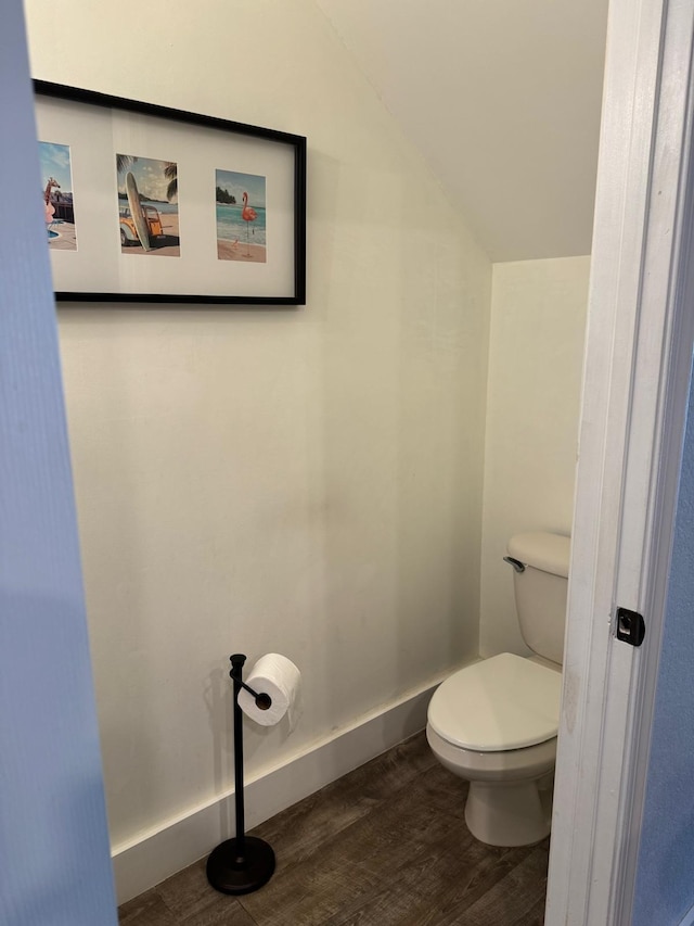 bathroom featuring vaulted ceiling, toilet, and hardwood / wood-style floors