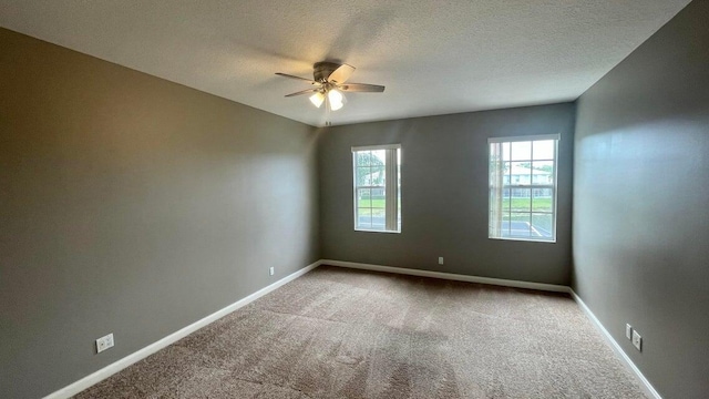 carpeted spare room with ceiling fan and a textured ceiling