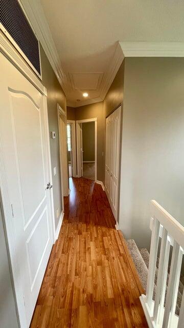 hallway with crown molding and hardwood / wood-style flooring