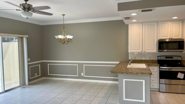 kitchen featuring stainless steel appliances, light stone counters, kitchen peninsula, decorative light fixtures, and white cabinets