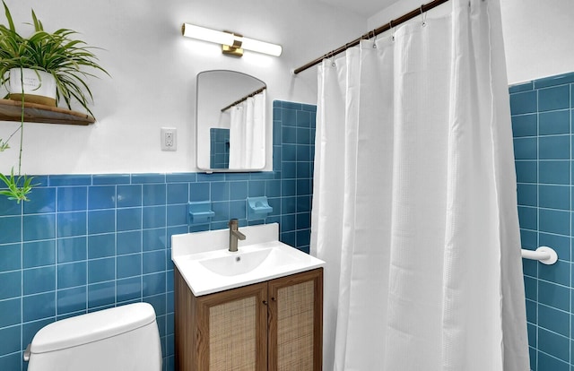 bathroom with vanity, tile walls, and toilet