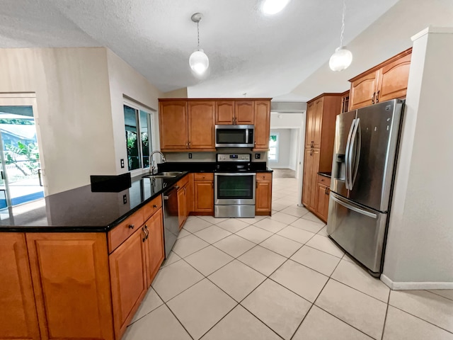 kitchen with lofted ceiling, sink, light tile patterned floors, decorative light fixtures, and stainless steel appliances