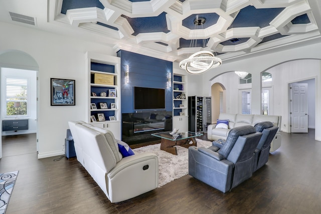 living room with coffered ceiling, an inviting chandelier, ornamental molding, dark hardwood / wood-style floors, and beam ceiling