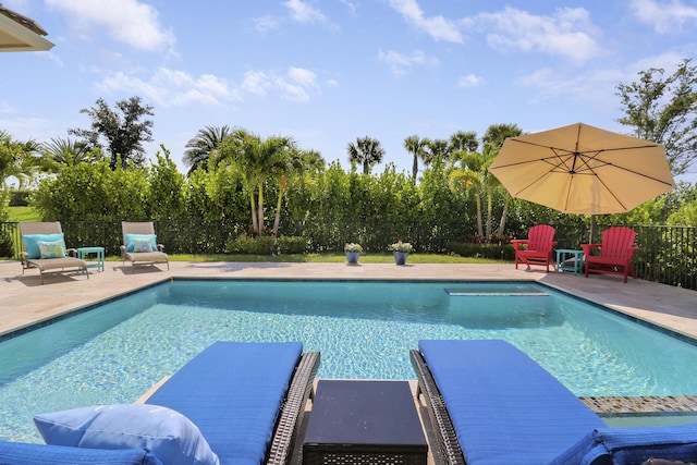 view of pool with a diving board and a patio area